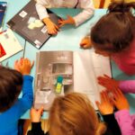 Dei bambini condividono la lettura di alcuni albi illustrati