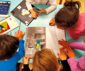Dei bambini condividono la lettura di alcuni albi illustrati